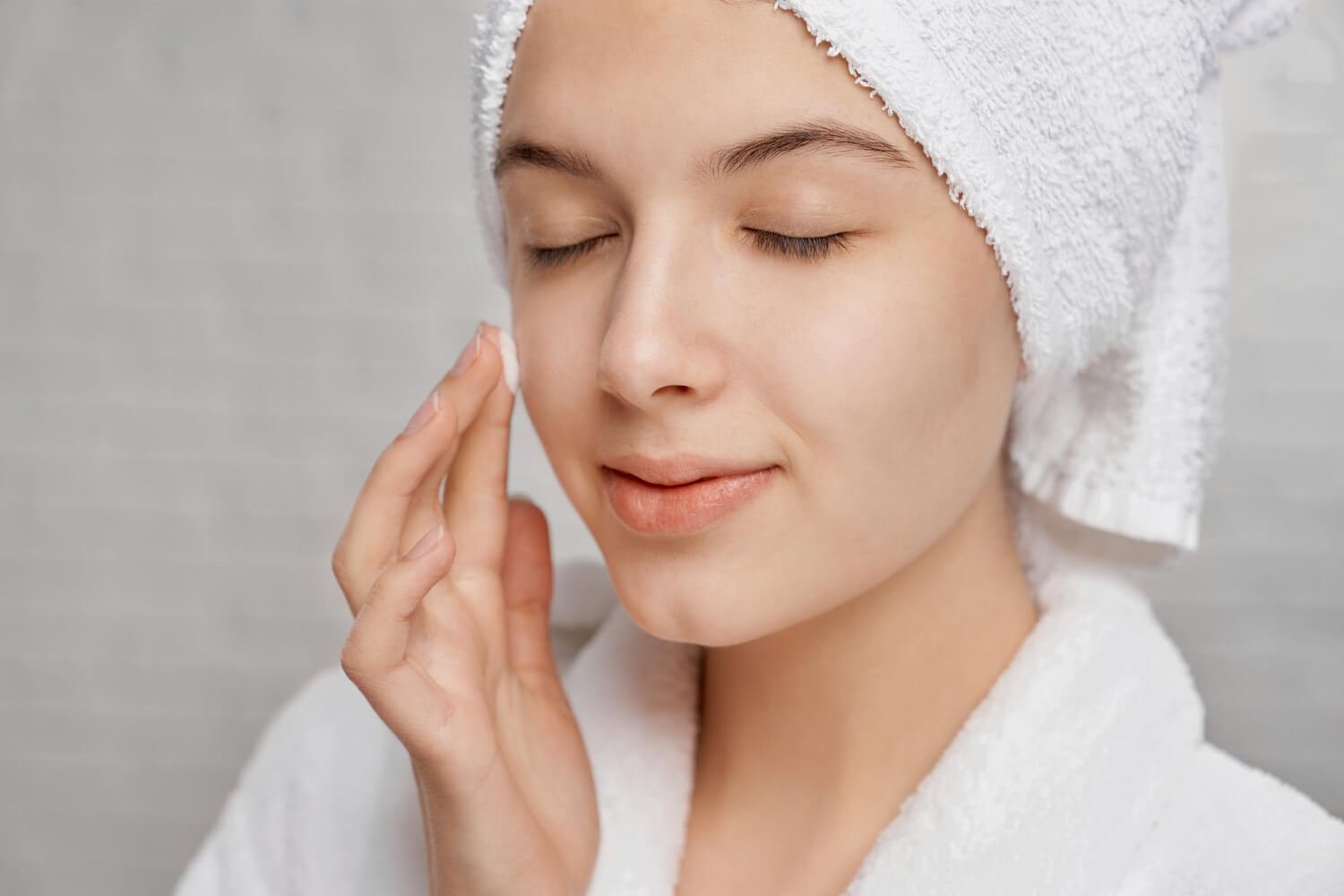 woman with closed eyes applying moisturizer face.jpg